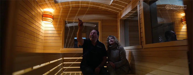 Anton und Tanja Kraack sitzen in einem Saunawagen der Schäferwagen Manufaktur